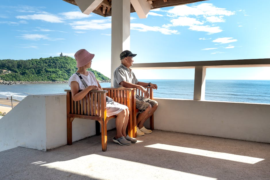 Senior couple sitting on balcony chairs, enjoying a relaxing ocean view